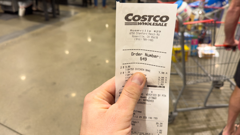 Hand holding a Costco receipt