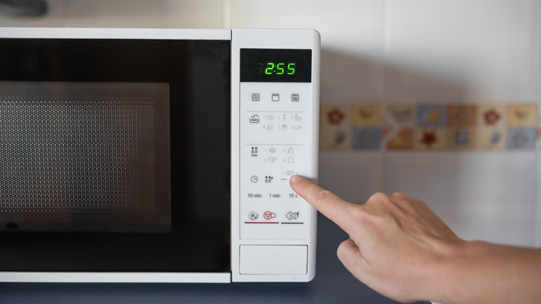 Person pressing microwave buttons