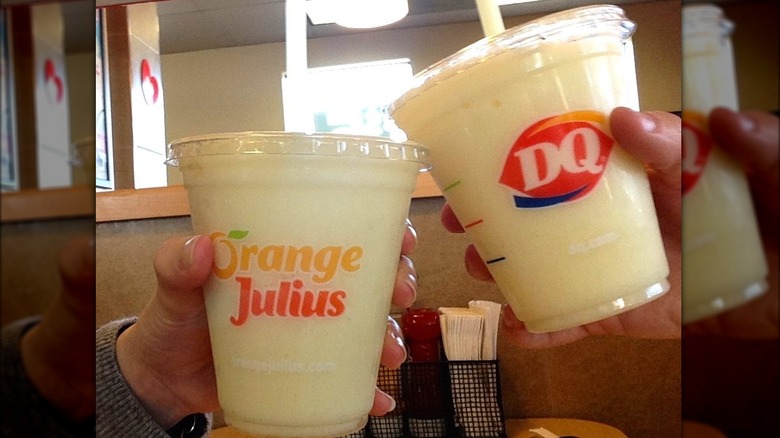 People holding Orange Julius drinks