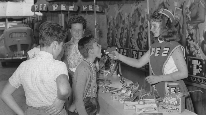 An employee giving kids PEZ from the 1950s space gun dispenser
