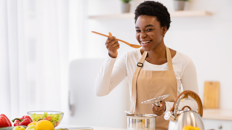 woman tasting something in pot