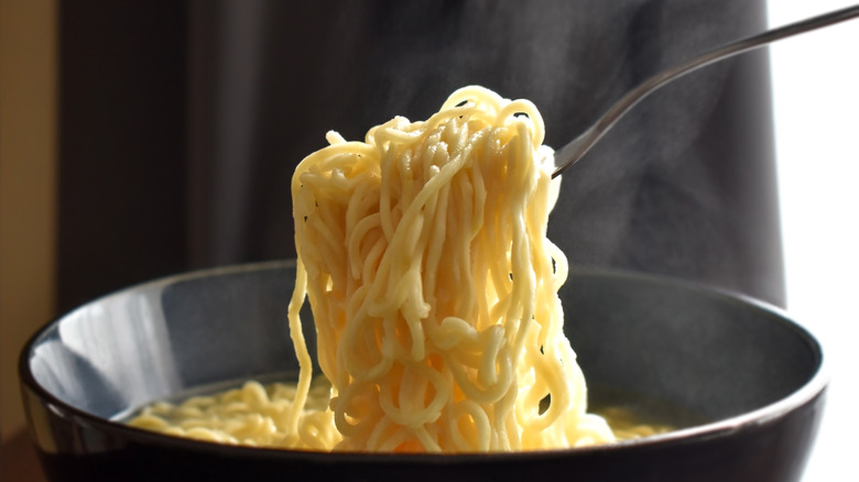 Instant ramen being scooped with a fork