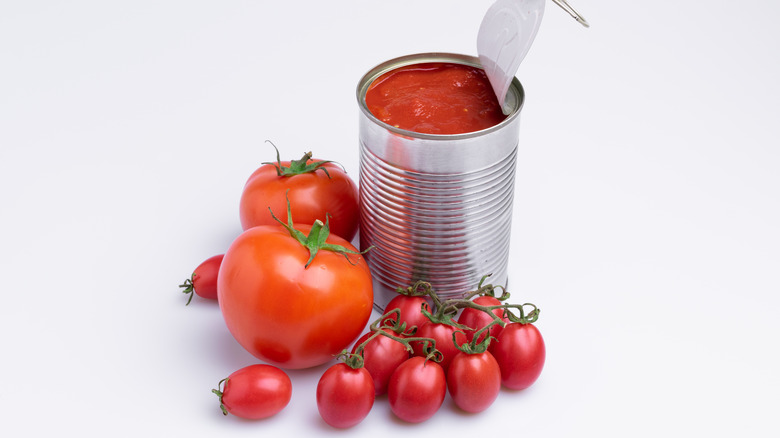 tomatoes sitting next to plain tin can