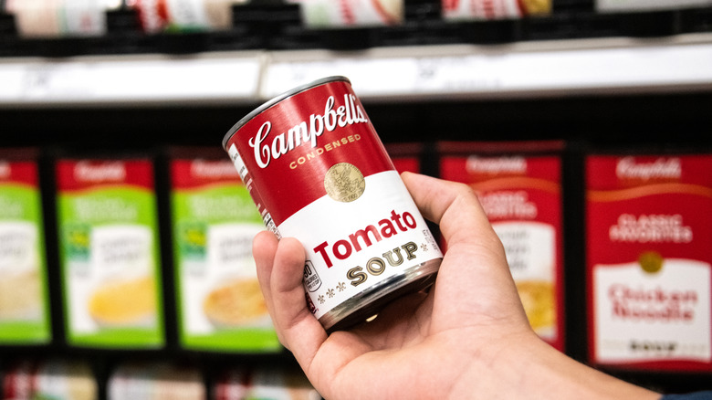 holding can of tomato soup