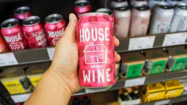 Hand holding a can of wine in aisle 