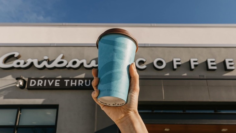 Hand holding blue Caribou coffee
