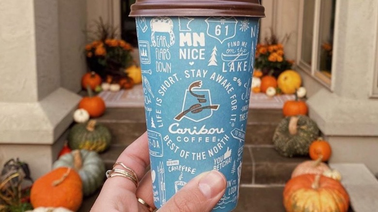 hand holding Caribou Coffee cup