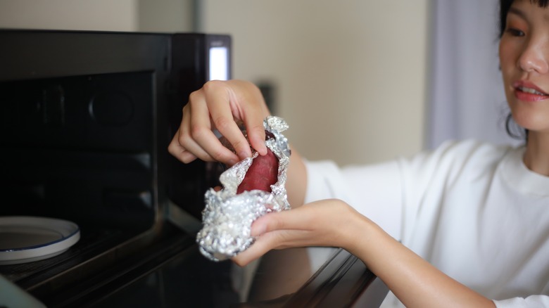 Woman checking microwaved potato 