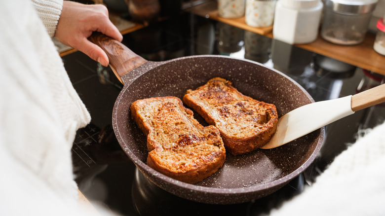 French toast cooking in nonstick skillet on stove