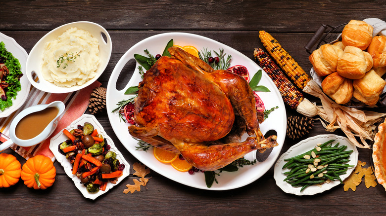 Traditional Thanksgiving turkey dinner with sides on dark table