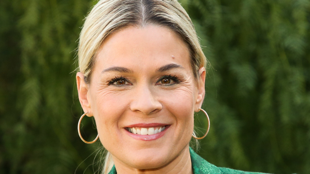 Cat Cora smiling with gold hoops