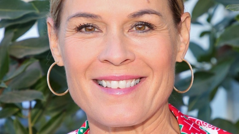 Cat Cora with hoop earrings and wide smile