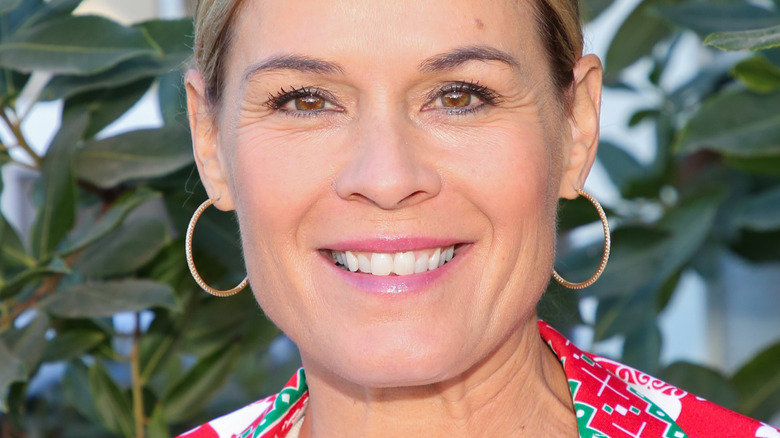 Cat Cora with hoop earrings and wide smile