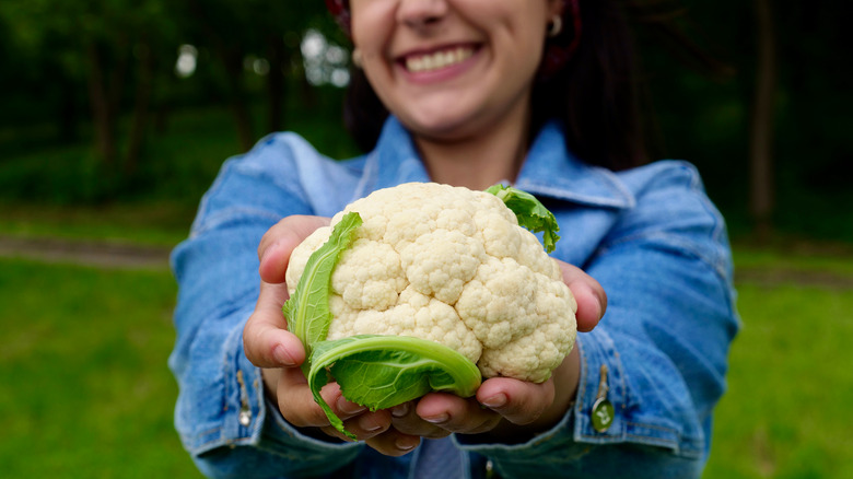 woman holding whole cauliflower