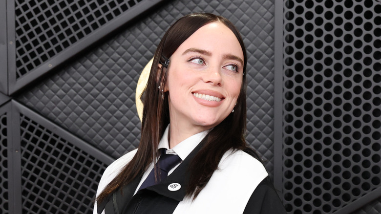 Billie Eilish smiles in front of black backdrop