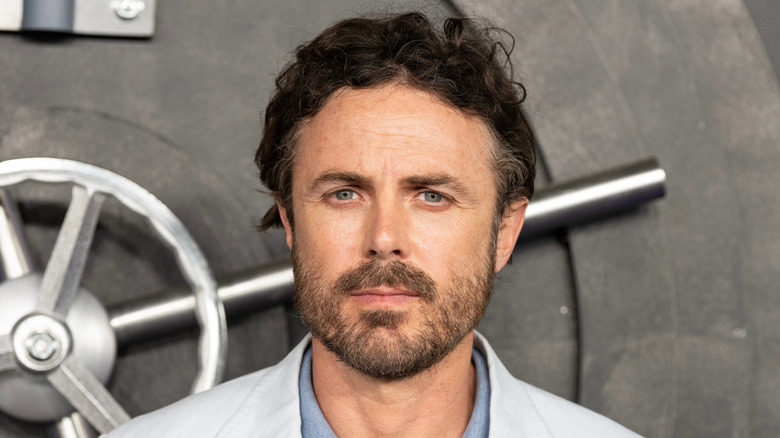 Casey Affleck poses in front of a vault prop