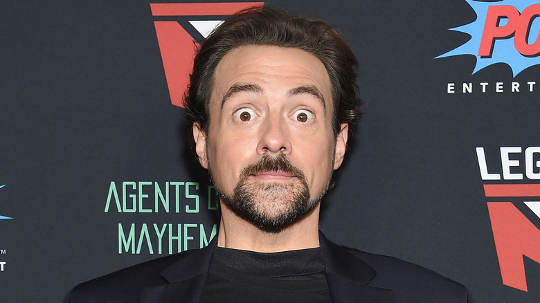 Kevin Smith looks shocked in front of backdrop