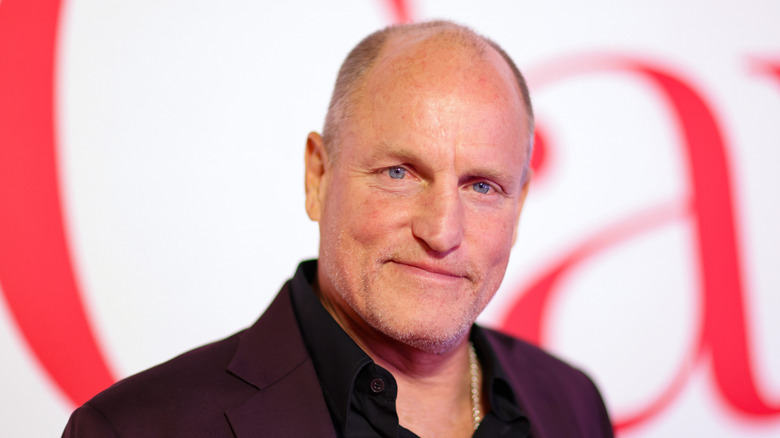 Woody Harrelson against a white backdrop with red writing