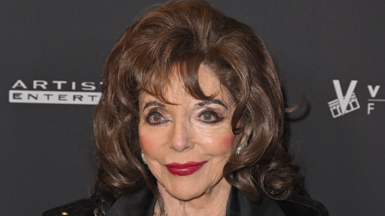 Joan Collins posing for cameras at publicity event