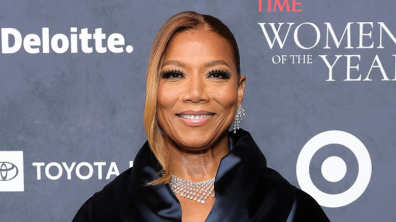 Queen Latifah wearing diamond jewelry against an awards backdrop