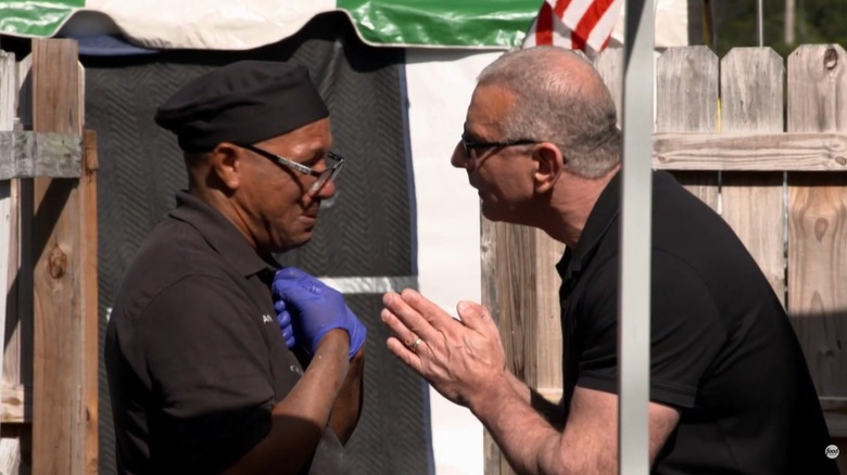 Robert Irvine has a discussion with a restaurant owner, preacher, and chef Andrew in an episode of Restaurant Impossible