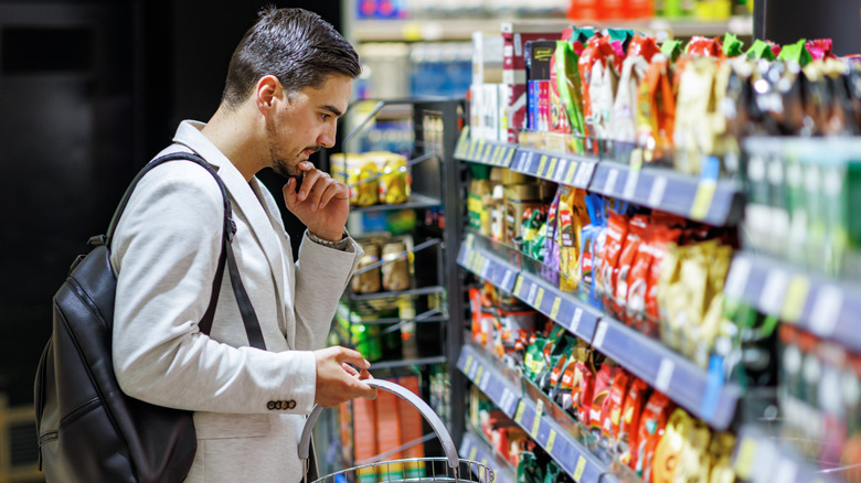 Man searching through convenience store aisle