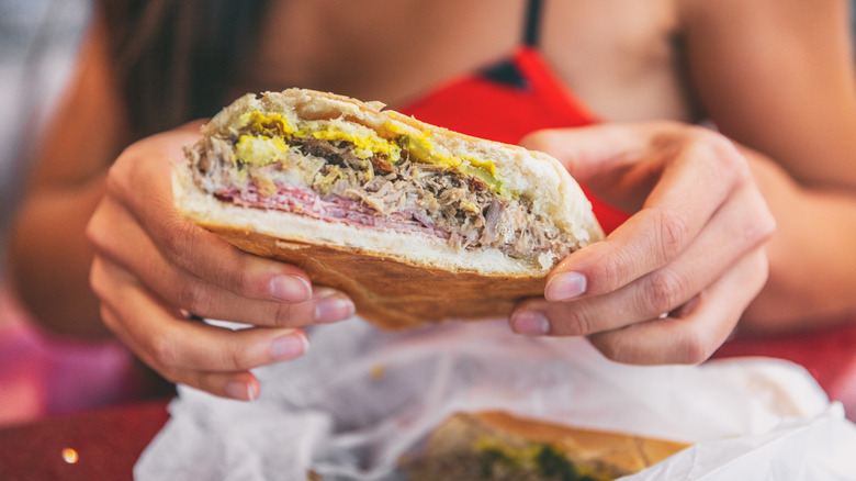 woman holding Cuban sandwich