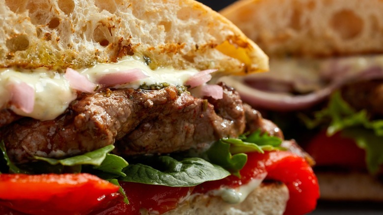 Close up of Firebirds steak sandwich sliced to show fillings