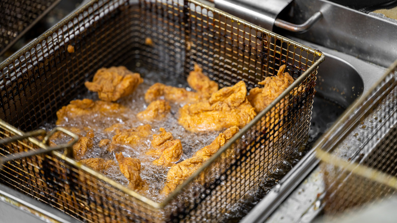 Chicken tenders cooking in an open deep fryer