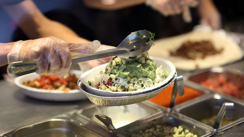 Worker at Chipotle preparing an order for a customer