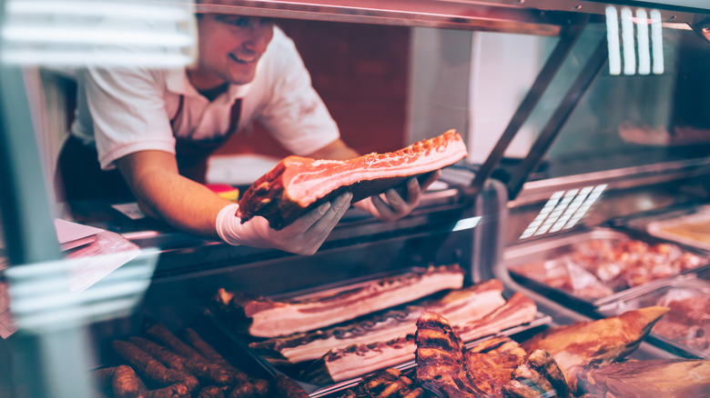 butcher adding meat to the case