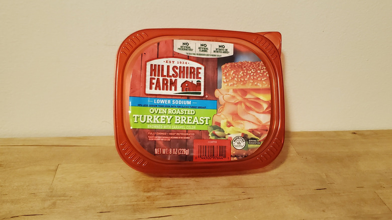 a container of Hillshire Farm sliced turkey breast on wooden surface