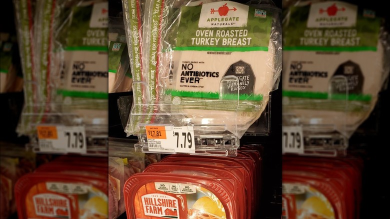 packages of Applegate sliced turkey and Hillshire farm in deli meat aisle at grocery store