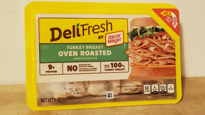 a container of Oscar Mayer sliced turkey breast on wooden surface
