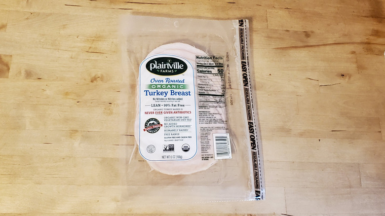 a pouch of Plainville Farms organic sliced turkey on wooden surface