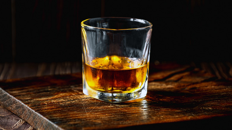 Glass of bourbon on a wood counter