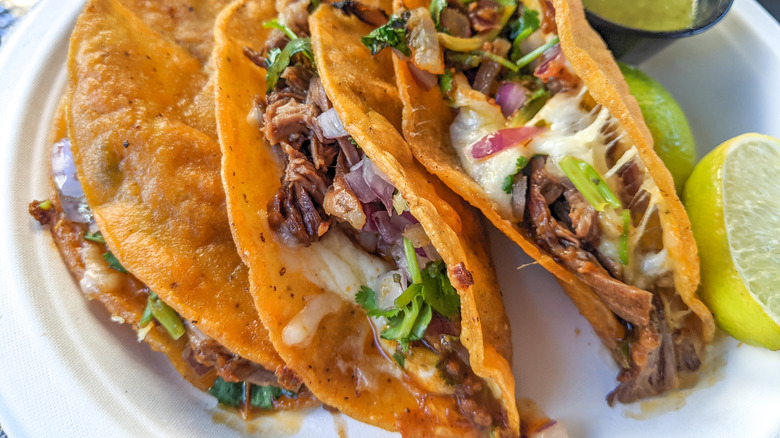 quesabirria taco with cheese and  lime slices