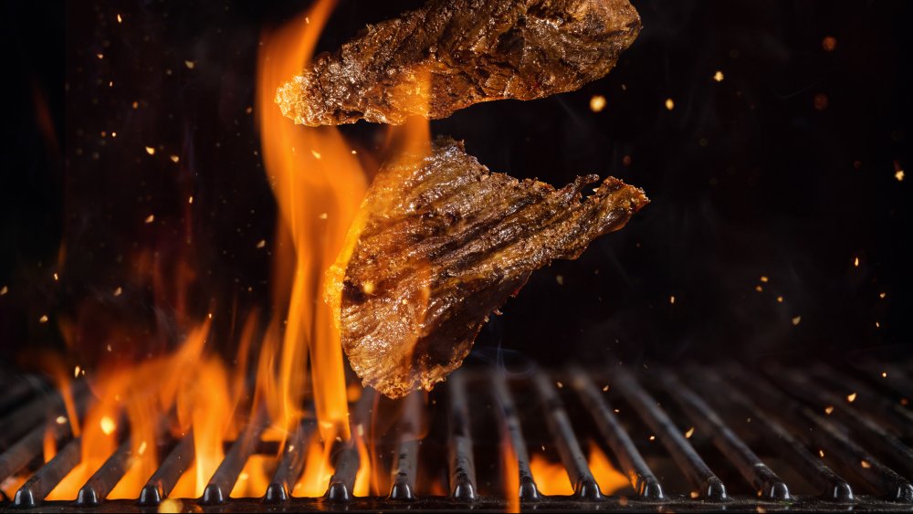 Beef steaks on flaming grill