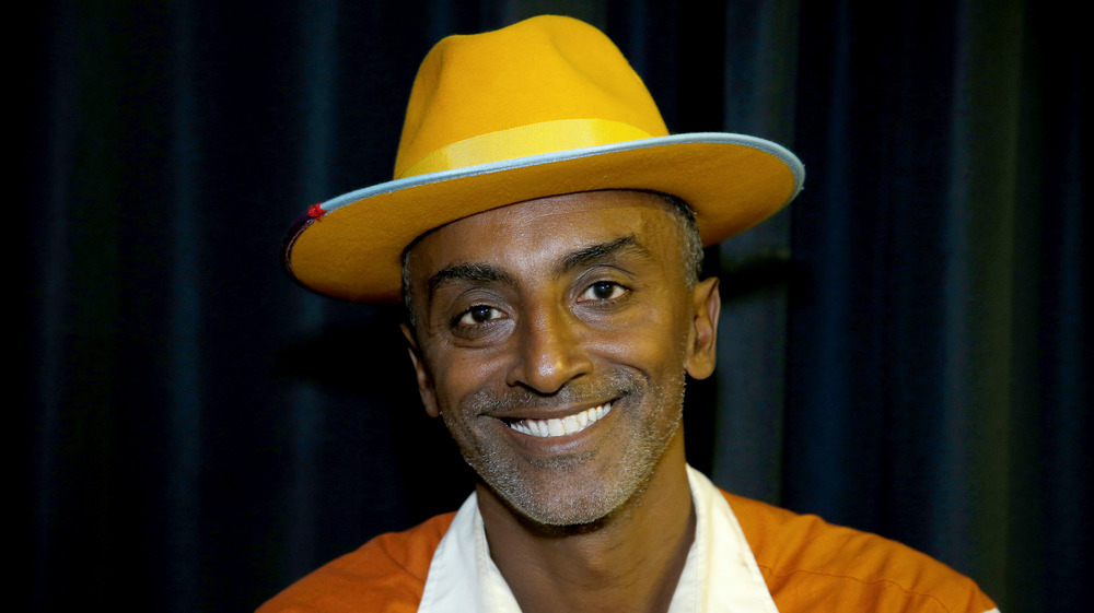 Chef Marcus Samuelsson smiles wearing a hat