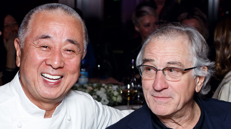 Chef Nobu Matsuhisa with Robert De Niro sitting at a table