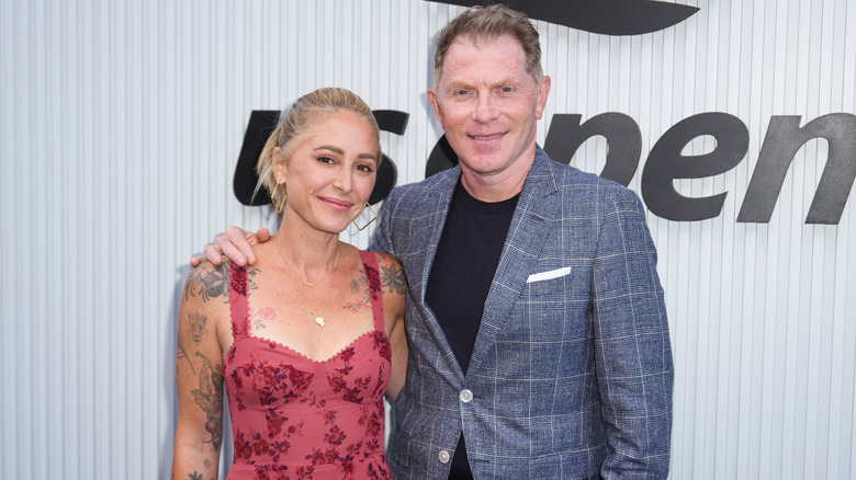 Bobby Flay and chef Brooke Williamson posing together at a publicity event.