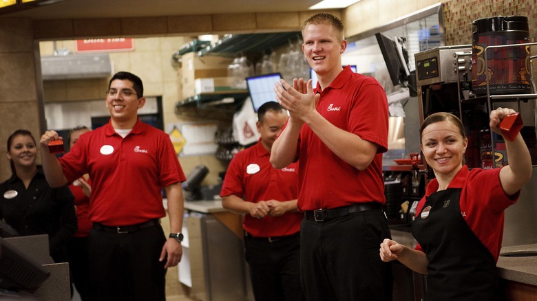 Happy Chick-fil-A workers cheering and smiling