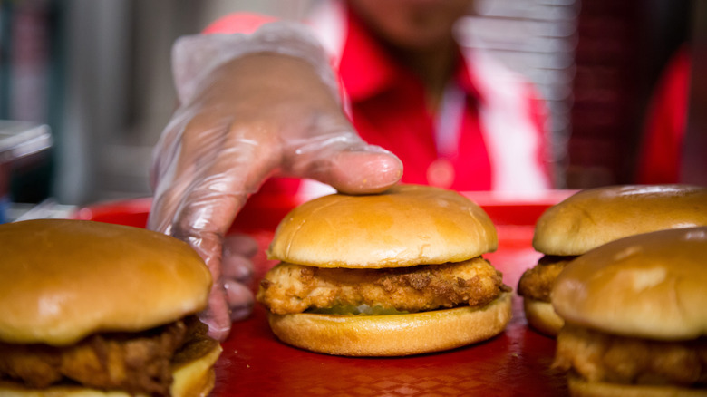 A Chick-fil-A employee handling fried chicken sandwiches