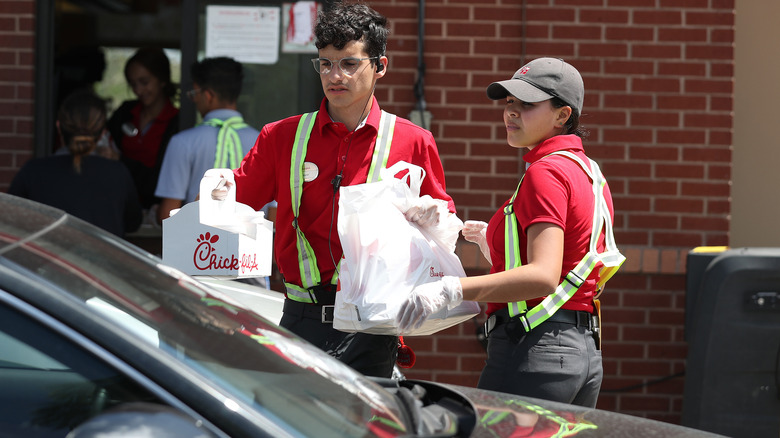 Chick-fil-A employee bringing order to car