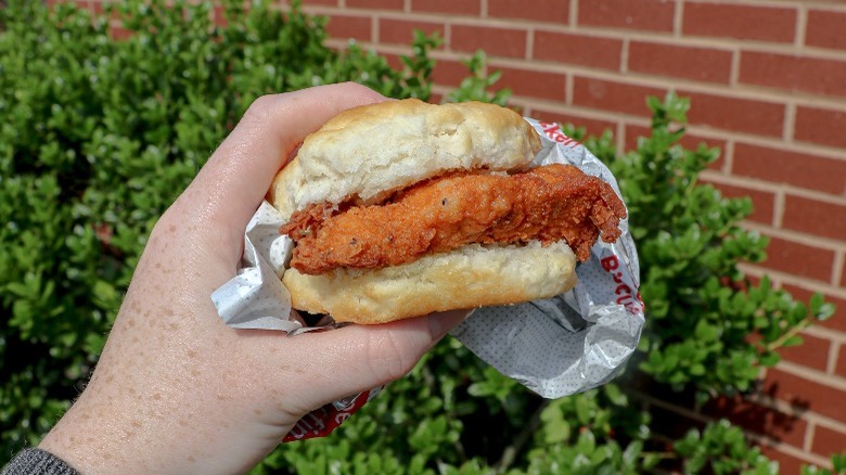 Person holding a Spicy Chicken Biscuit from Chick-fil-A