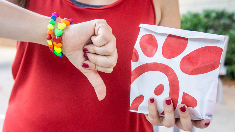 Person holding Chick-fil-A bag with thumb down