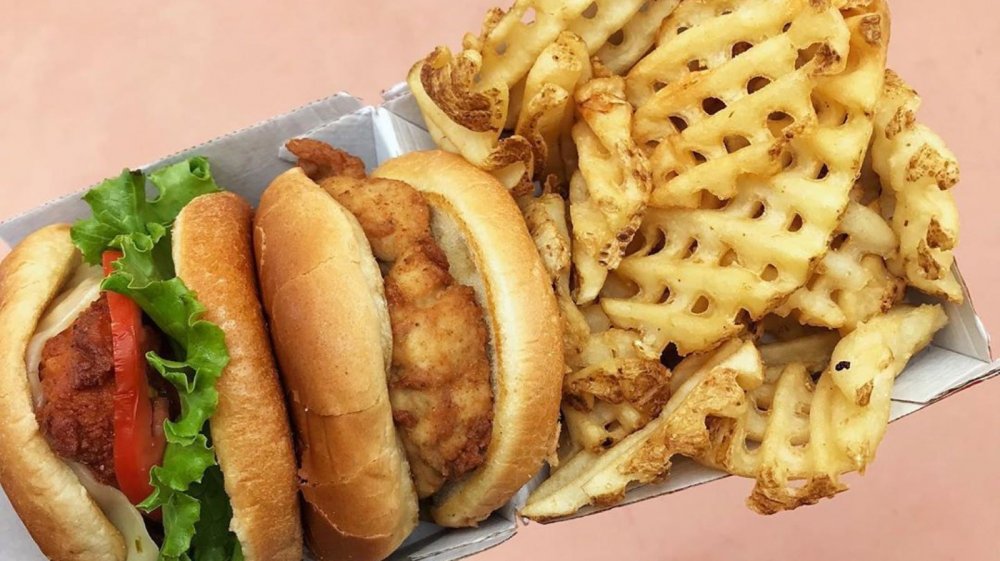 Two different Chick-fil-A chicken sandwiches with waffle fries