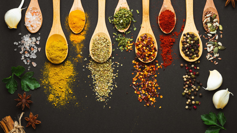 overhead view of assorted spices in wooden spoons