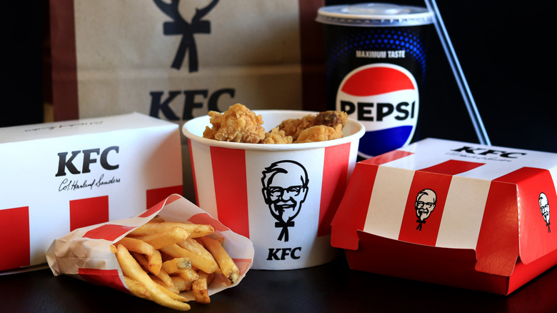 A KFC meal with fried chicken bucket, Pepsi cup, and fries