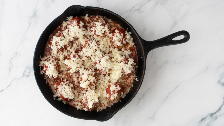 Sauced meatballs topped with cheese in skillet